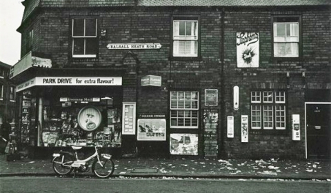 Image of a street in Balsall Heath, Birmingham taken in the late 1960s. Image is of Victorian terrace houses and a corner shop with a bicycle outside.