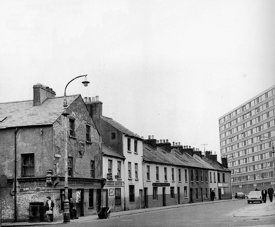 Historical black and white picture of old streets in Derry City, with old and new buildings.